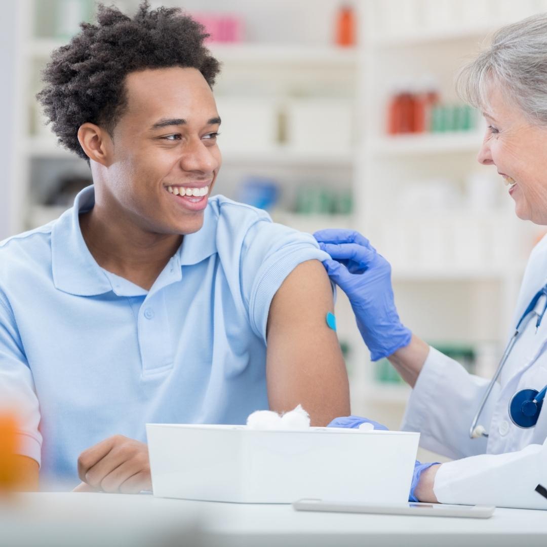 Man smiling at nurse administering the vaccine