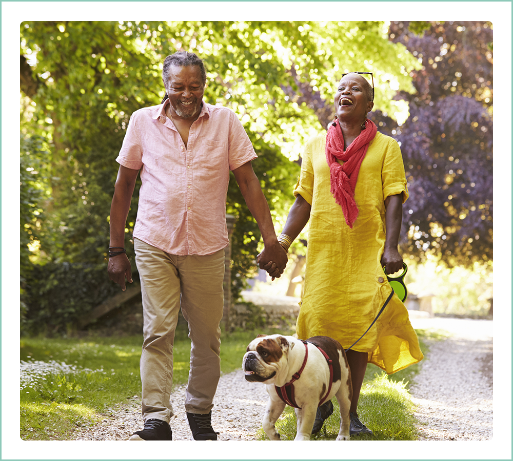 Happy older couple walking their dog