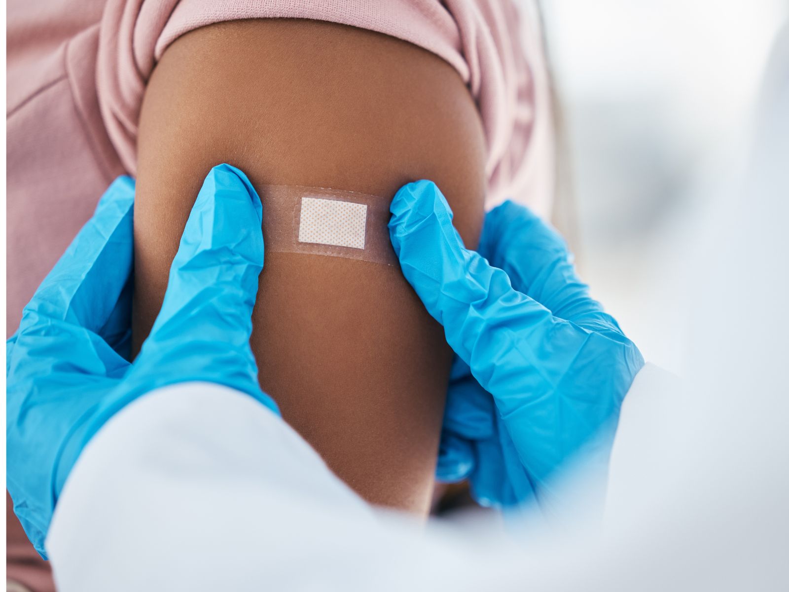 doctor or nurse applying a bandage, post vaccination